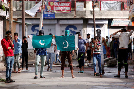 Protesters hold the flag of Pakistan during a protest in Srinagar against the recent killings in Kashmir, August 26, 2016. REUTERS/Danish Ismail/Files