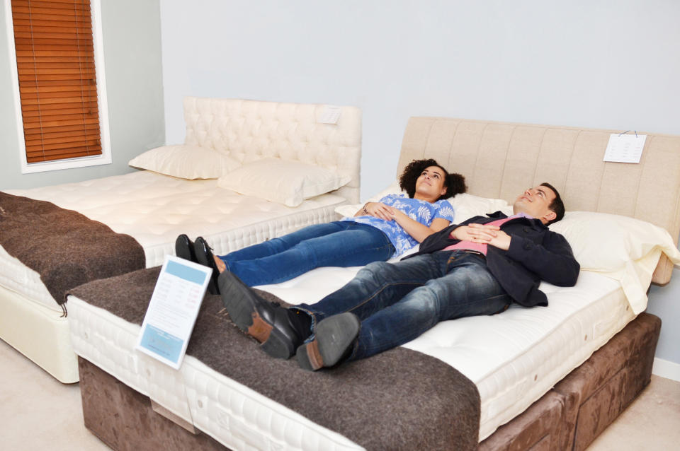 a couple trying out a bed in a store