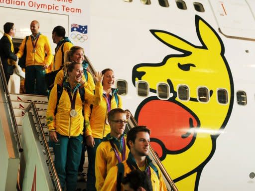 Australian Olympians disembark from a Qantas 747-400 plane inside a hangar at the Sydney Domestic Airport on August 15, 2012. Recriminations have begun in Australia after they finished only 10th at the London Games, down from sixth in Beijing, with just seven golds for their worst victory tally in 20 years