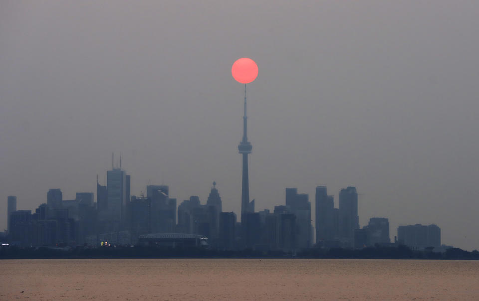 TUn raro sol rojo se alza en un cielo gris sobre la ciudad de Toronto, Canadá. Ello ha sido provocado por la gran cantidad de humo que ha llegado a esa urbe desde los incendios forestales que azotan el oeste de ese país. (Getty Images)