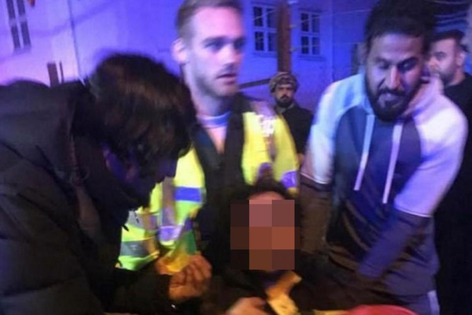 Attack: medics attend to the injured after a red Nissan drove into a group of people gathered outside the Islamic centre