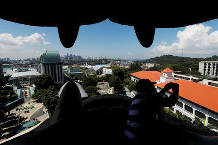 FILE PHOTO: A view of Sentosa Island through the mouth of the Merlion statue in Singapore June 4, 2018. Picture taken June 4, 2018. REUTERS/Edgar Su/File Photo