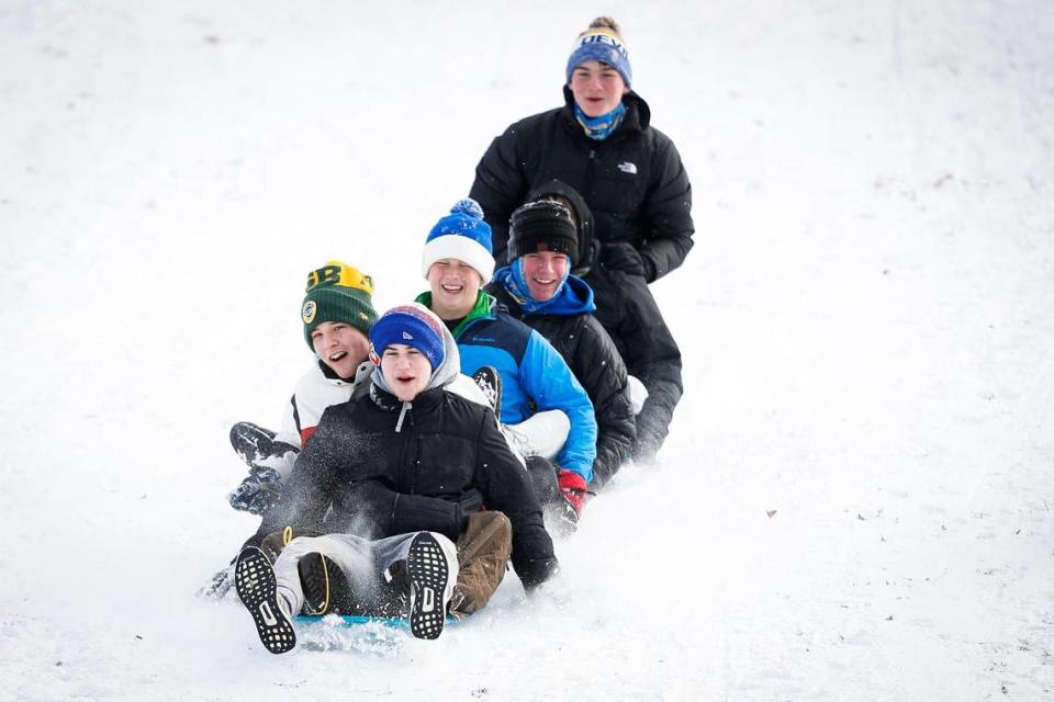 Riley Schneider, 16, Sam Sizemore, 16, Deacon Carter, 15, Finn Kenny, 15, and Chardy Tierney, 16, sled down the hill behind the former Shriners Hospital on Lexington’s Richmond Road Friday, Jan. 7, 2022.