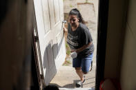 Roxanne Schaefer, of West Warwick, R.I., enters an outside door to her apartment building, in West Warwick, Tuesday, July 27, 2021. Schaefer, who is months behind on rent, is bracing for the end to a CDC federal moratorium Saturday, July 31, 2021, a move that could result in millions of people being evicted just as the highly contagious delta variant of the coronavirus is rapidly spreading. (AP Photo/Steven Senne)