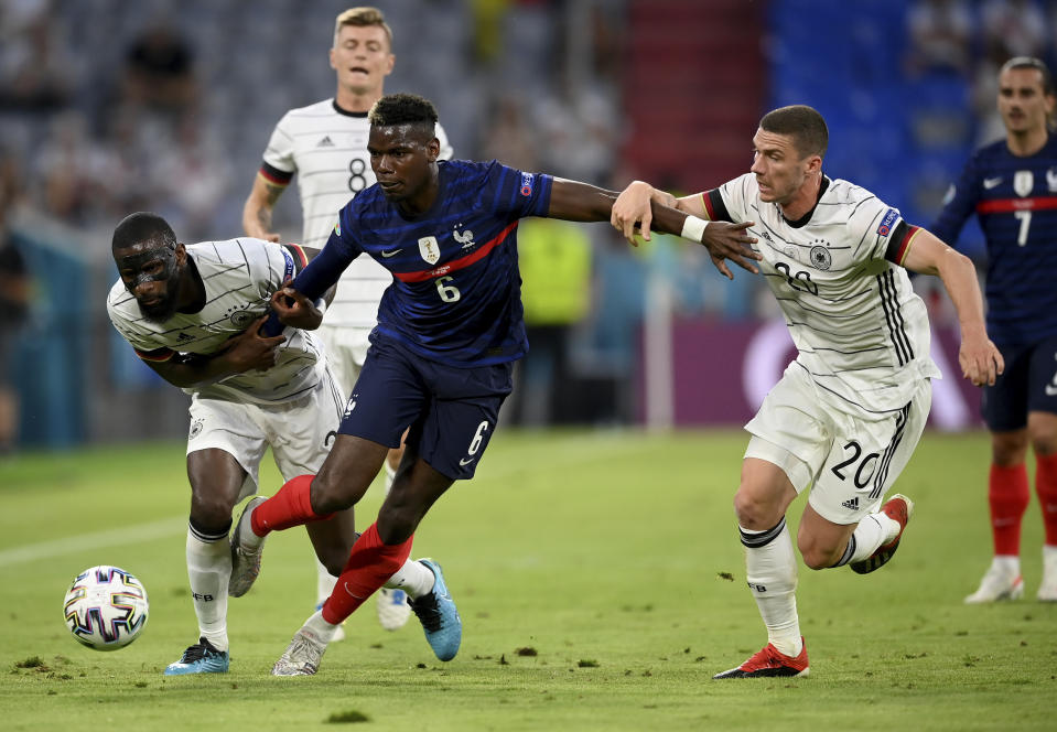 Germany's Antonio Ruediger, left, and Germany's Robin Gosens, right, challenge France's Paul Pogba during the Euro 2020 soccer championship group F match between France and Germany at the Allianz Arena stadium in Munich, Tuesday, June 15, 2021. (Matthias Hangst/Pool via AP)