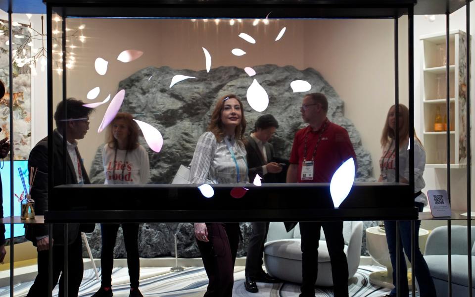 People look at an exhibit of an LG transparent TV at the CES show in Las Vegas