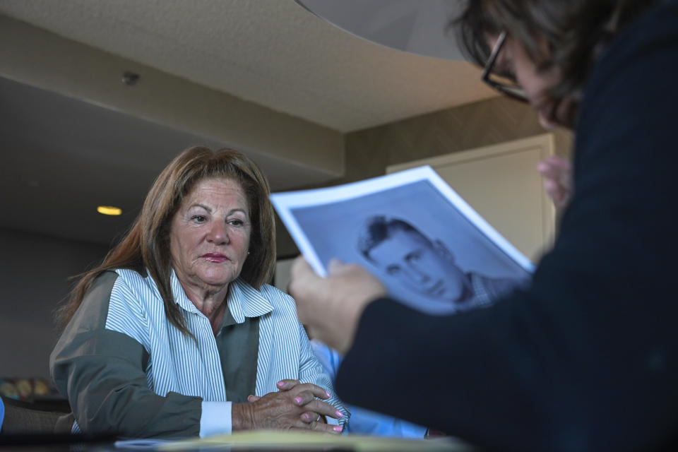 Anna Salton Eisen holds a photo of Moses Tuchman, father of Miriam Kershner, left, during a gathering for families of Holocaust survivors, Sunday, Sept. 26, 2021, in East Brunswick, N.J. “We all felt so connected by our parents, and we all knew that our parents survived because of each other,” says Kershner, a retired teacher, 65. (AP Photo/Brittainy Newman)