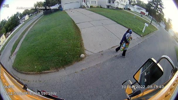 PHOTO: In surveillance video, Sue Figueroa, a school bus driver in Michigan, is seen carrying a toddler who had been left on the side of the road, into her bus. (Kellogsville Public Schools via GMA)