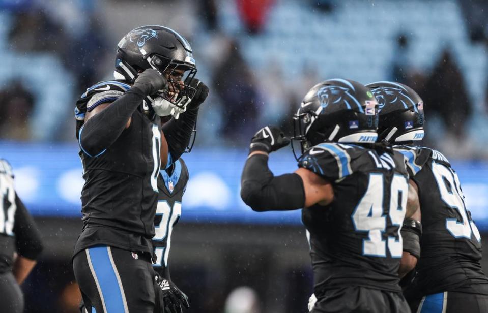 Carolina Panthers linebacker Brian Burns, left, and Frankie Luvu flex at each other after making a play against Atlanta Falcons at the Bank of America Stadium in Charlotte, N.C., on Sunday, December 17, 2023.