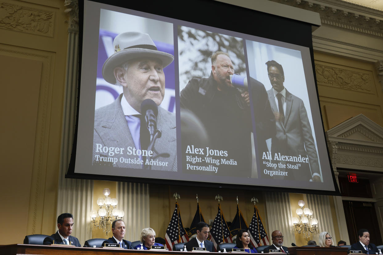 Images of Roger Stone, Alex Jones and Ali Alexander appear on a video screen above Jan. 6 committee members.