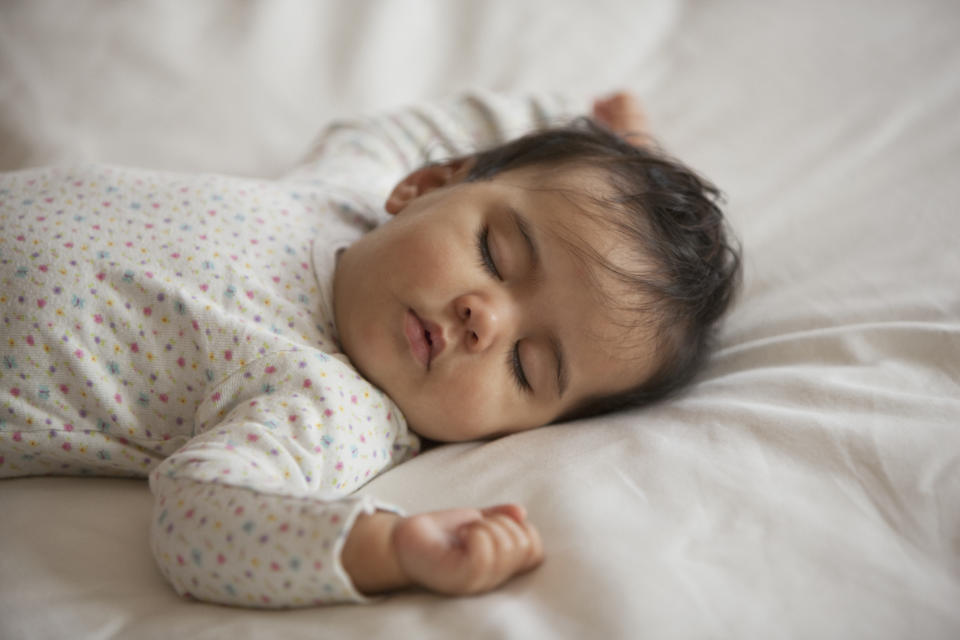 baby sleeping on white sheet