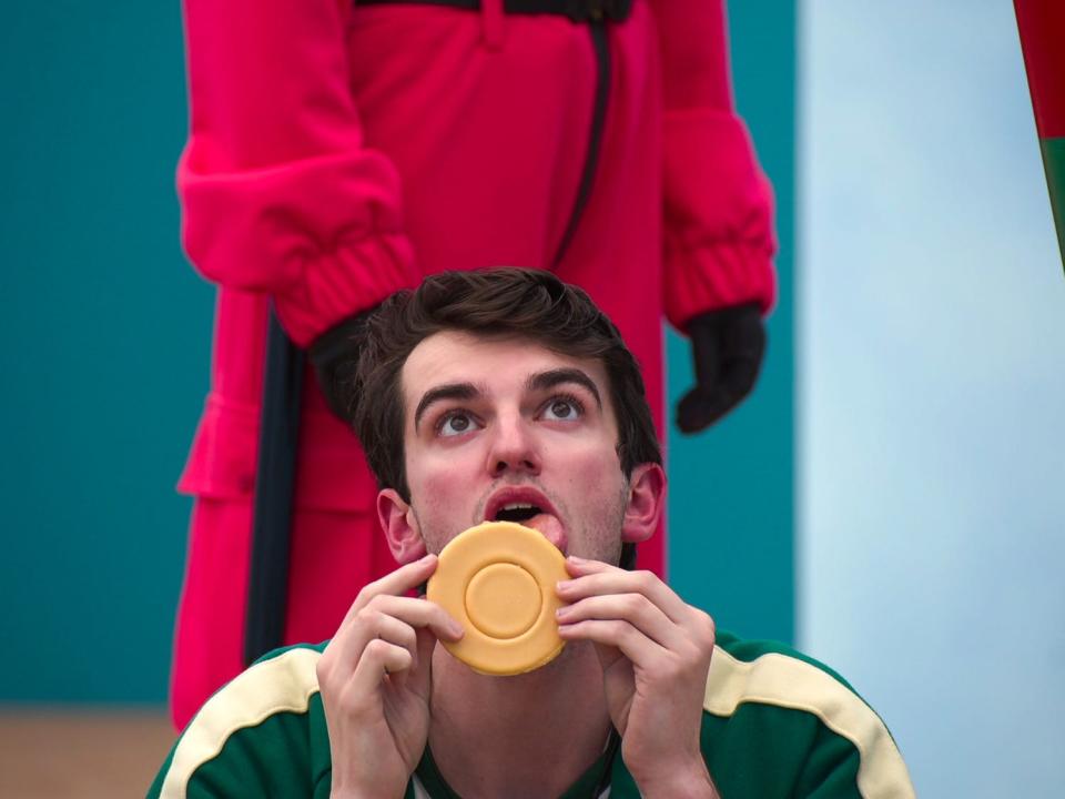 Trey Plutnicki licking a round cookie