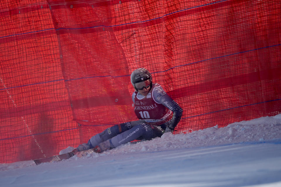 Italy's Federica Brignone sits up after crashing during an alpine ski, women's World Cup downhill race, in Cortina d'Ampezzo, Italy, Friday, Jan. 26, 2024. (AP Photo/Giovanni Zenoni)