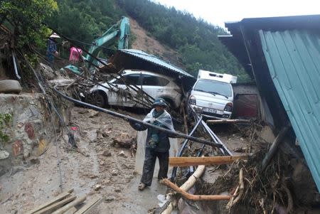 A paramilitary clears debris of a landslide in Lai Chau province, Vietnam June 25, 2018. VNA/Quy Trung via REUTERS