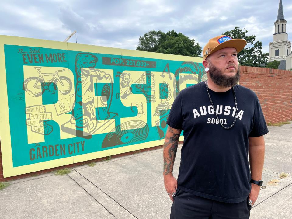 Jason Craig poses for a portrait outside his "RESPECT" between James Brown Arena and Bell Auditorium in downtown Augusta on Wednesday, Aug. 16, 2023.