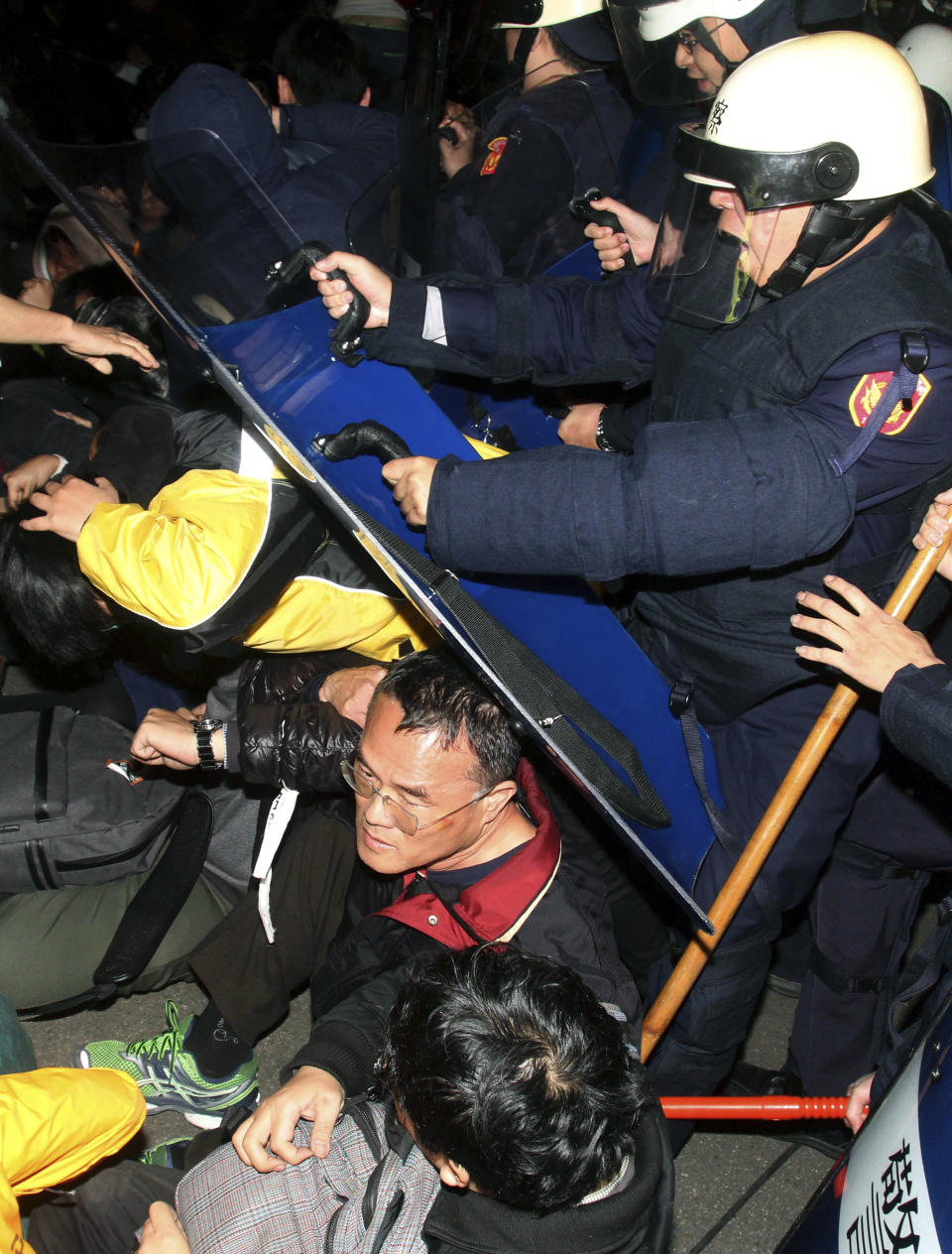 Students protesting against a China Taiwan trade pact scuffle with police after storming the government Cabinet offices in Taipei, Taiwan, Monday, March 24, 2014. Hundreds of protesters opposed to a far-reaching trade pact with China invaded Taiwan's Cabinet offices, marking a sharp escalation in a student-led movement against the island's rapidly developing ties with the communist mainland. (AP Photo/Chiang Ying-ying)