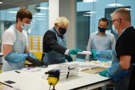 Britain's Prime Minister Boris Johnson (2L) wears PPE (Personal Protective Equipment) as he visits the Lighthouse Laboratory used for processing PCR samples at the Queen Elizabeth University Hospital campus in Glasgow, Scotland on January 28, 2021, during a COVID-19 related visit to the country. - Prime Minister Boris Johnson headed to Scotland on Thursday to praise the United Kingdom's collective response to coronavirus, in a bid to counter record support for independence. (Photo by Jeff J Mitchell / POOL / AFP) (Photo by JEFF J MITCHELL/POOL/AFP via Getty Images)