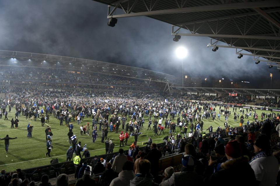 Finnish fans join players to celebrate their victory in the Euro 2020 Group J qualifying soccer match between Finland and Liechtenstein in Helsinki, Finland, on Friday, Nov. 15, 2019. Finland won 3-0 and have qualified for a major soccer tournament for the first time in their history. (Martti Kainuleinen/Lehtikuva via AP)