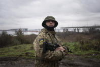 A Ukrainian serviceman patrols area near the Antonovsky Bridge which was destroyed by Russian forces after withdrawing from Kherson, Ukraine, Thursday, Dec. 8, 2022. (AP Photo/Evgeniy Maloletka)