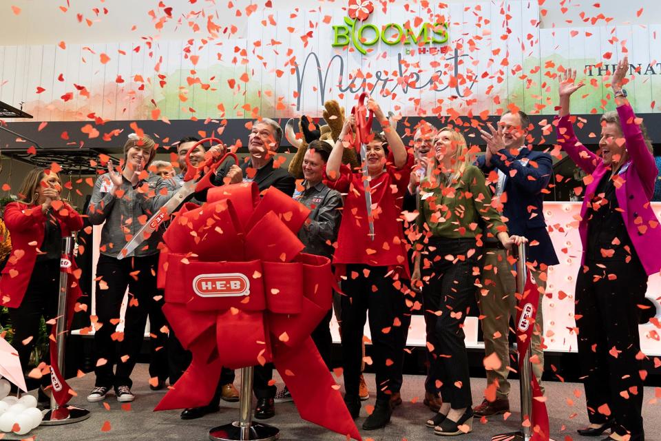 H-E-B leadership cheers as confetti falls during the grand opening of the new H-E-B at Lake Austin Boulevard and Exposition.