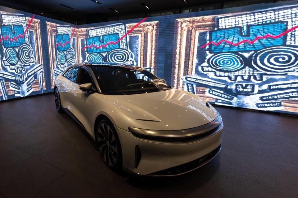 Un modelo Lucid Air Grand Touring rodeado de ilustraciones animadas en la sala de exposición Brickell Studio de Lucid, una nueva empresa de autos eléctricos de lujo, dentro del Brickell City Centre de Miami, Florida, el viernes 2 de diciembre de 2022.