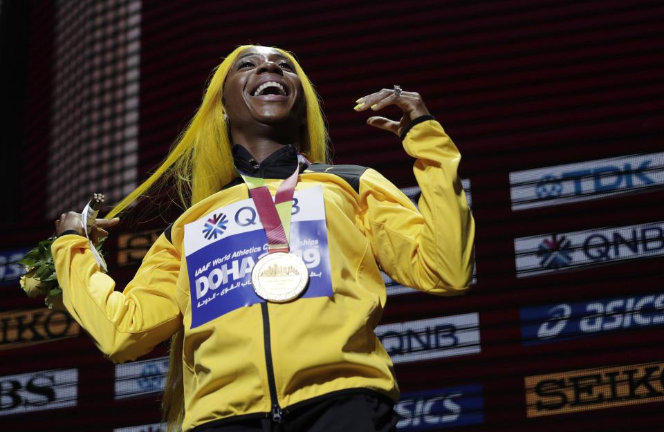 FILE - In this file photo dated Monday, Sept. 30, 2019, Shelly-Ann Fraser-Pryce of Jamaica, gold medalist in the women's 100 meters, reacts during the medal ceremony at the World Athletics Championships in Doha, Qatar. Moving from their sports field to the living room, many athletes around the world are doing their bit to boost public health during the coronavirus pandemic lockdown, and one of them is two-time 100-meter champion Shelly-Ann Fraser-Pryce of Jamaica, who is reading her children's book. (AP Photo/Nariman El-Mofty, FILE)