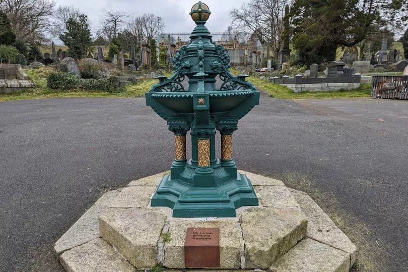 The Victorian Drinking Fountain at Belfast City Cemetery - An ornate wrought iron dark green design set on granite