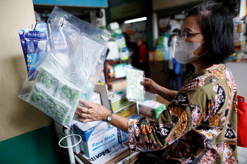 Woman wearing a mask shops for surgical masks at a whole-sale market for medical stuffs, following the outbreak of the new coronavirus in China, in Jakarta