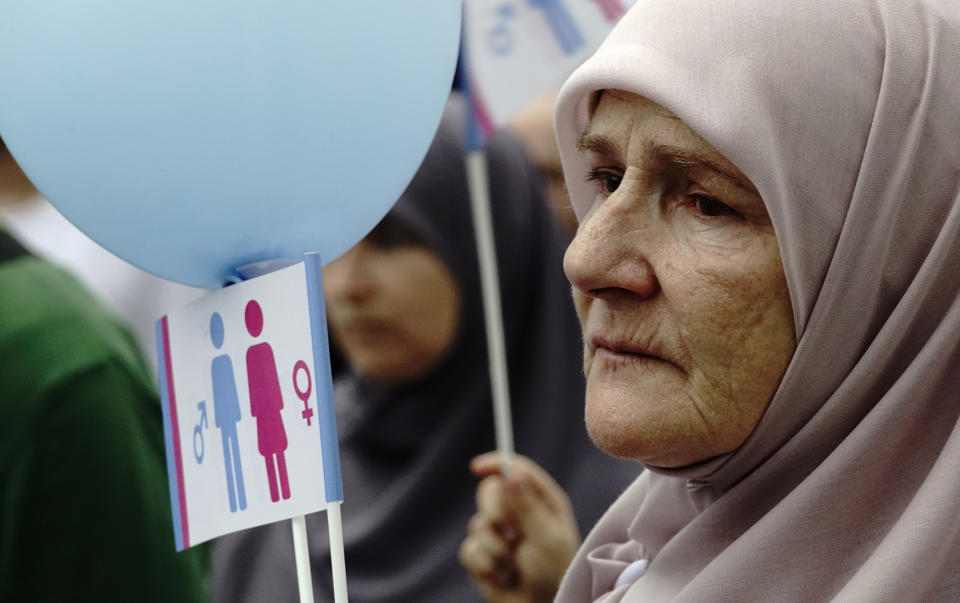 A woman holds a banner as she takes part in what was said was a gathering designed to promote traditional family values in Sarajevo, Bosnia, Saturday, Sept. 7, 2019. Several hundred people have marched in Bosnia's capital Sarajevo to express their disapproval of the Balkan country's first ever LGBT pride parade scheduled for Sunday. (AP Photo/Eldar Emric)