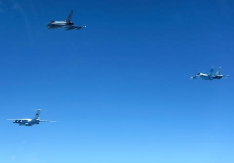 A Russian IL-76 Candid transport plane (L) and an SU-30 Flanker fighter (R) shepherded by an RAF Typhoon fighter (C). June 15, 2019. - Credit: RAF/REX