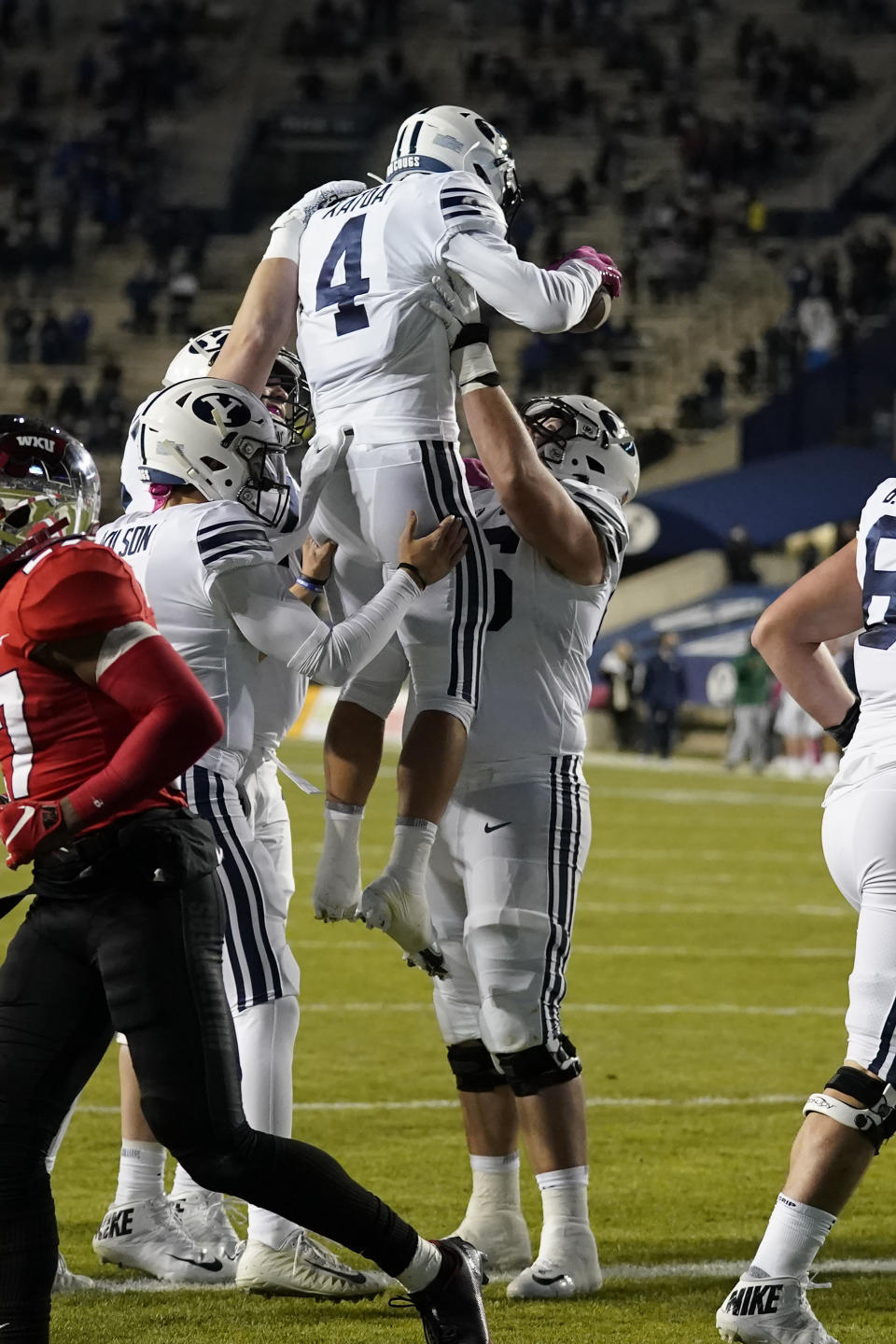 BYU running back Lopini Katoa (4) celebrates with teammates after scoring against Western Kentucky during the first half of an NCAA college football game Saturday, Oct. 31, 2020, in Provo, Utah. (AP Photo/Rick Bowmer, Pool)