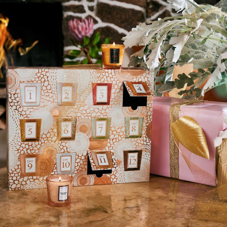 the Voluspa Advent Calendar with a couple open with two candles around it