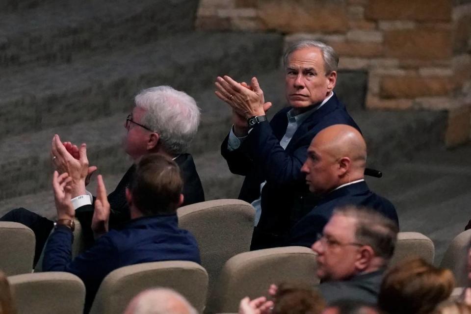 Texas Gov. Greg Abbott, right, Lt. Gov. Dan Patrick, left, and others applaud first responders during a prayer vigil after a mass shooting the day before Sunday, May 7, 2023, in Allen, Texas. (AP Photo/LM Otero)