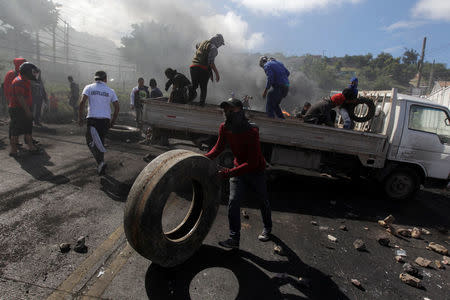 Supporters of Salvador Nasralla, presidential candidate for the Opposition Alliance Against the Dictatorship, unload a truck with rocks and tires for a barricade settled to block road during a protest caused by the delayed vote count for the presidential election in Tegucigalpa, Honduras December 1, 2017. REUTERS/Jorge Cabrera