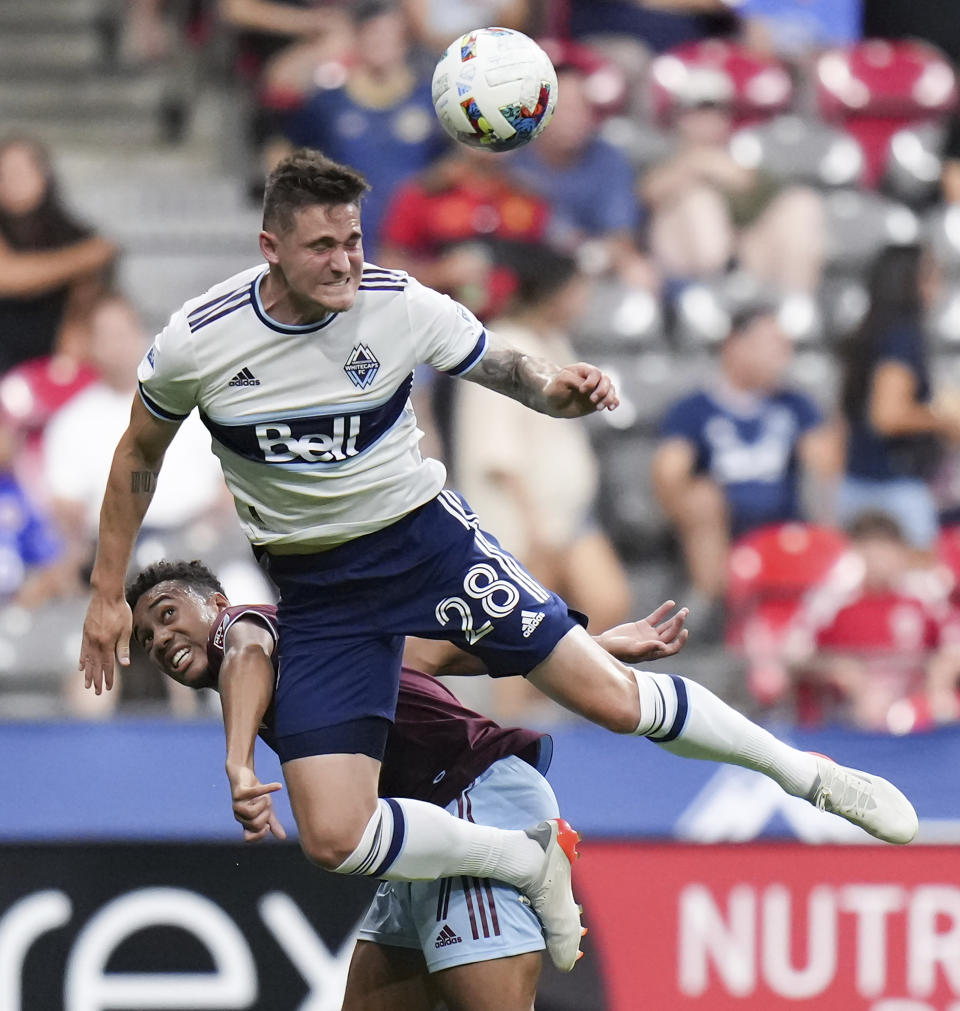 Vancouver Whitecaps' Jake Nerwinski, front, and Colorado Rapids' Jonathan Lewis vie for the ball during the second half of an MLS soccer match Wednesday, Aug. 17, 2022, in Vancouver, British Columbia. (Darryl Dyck/The Canadian Press via AP)