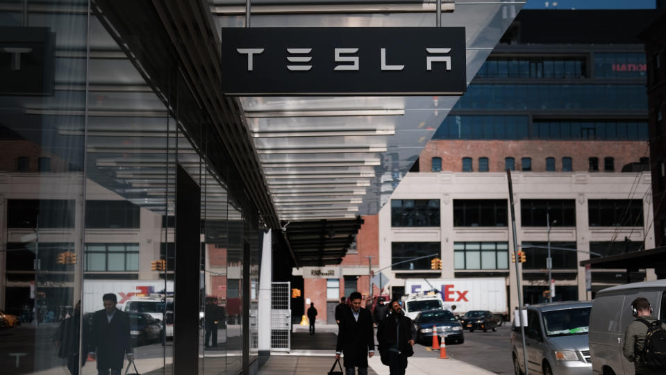 People walk by a Tesla showroom in Manhattan (Photo by Spencer Platt/Getty Images)