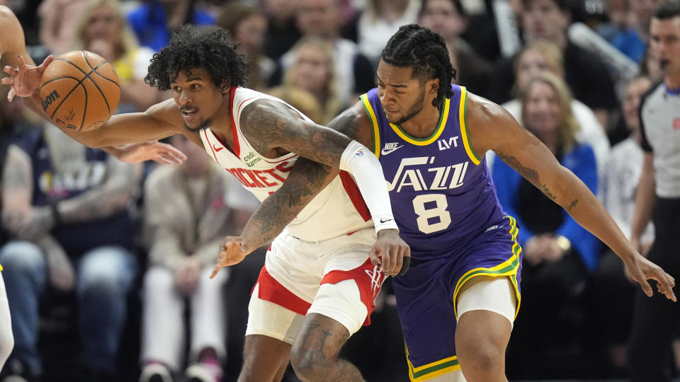 Houston Rockets guard Jalen Green, left, and Utah Jazz forward Brice Sensabaugh (8) battle for the ball during the first half of an NBA basketball game Thursday, April 11, 2024, in Salt Lake City. (AP Photo/Rick Bowmer)