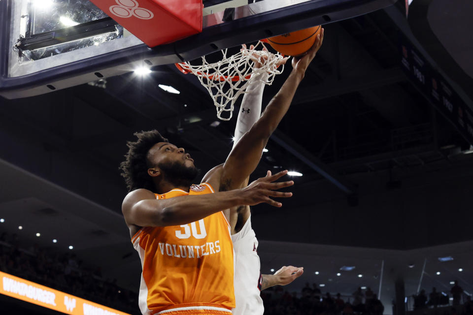 Tennessee guard Josiah-Jordan James (30) lays in a basket as Auburn forward Johni Broome (4) defends during the first half of an NCAA college basketball game Saturday, March 4, 2023, in Auburn, Ala. (AP Photo/Butch Dill)