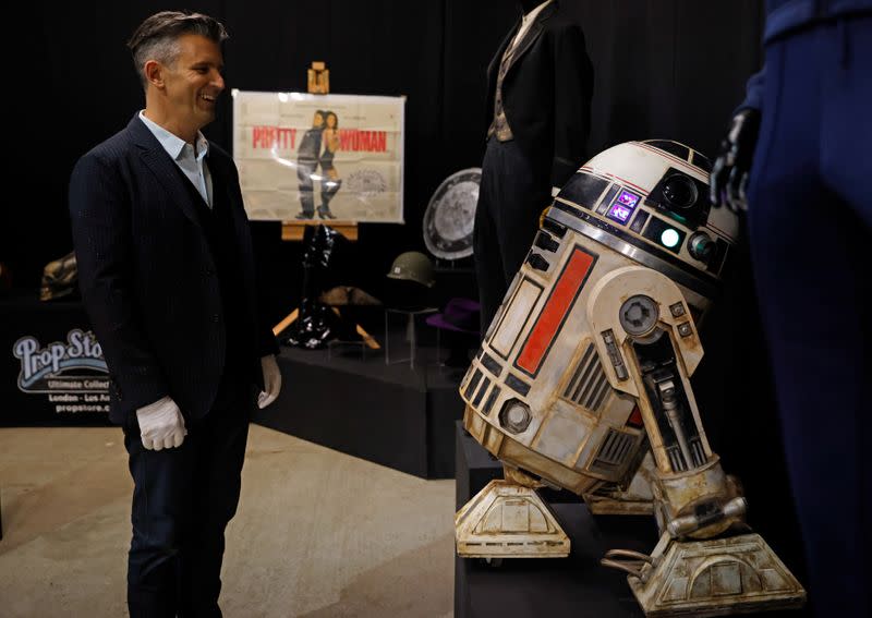 Stephen Lane, CEO of Prop Store, poses for a photograph with a R2-S8 droid from Star Wars film, Solo: A Star Wars Story, at a preview of a movie and TV memorabilia auction in Rickmansworth