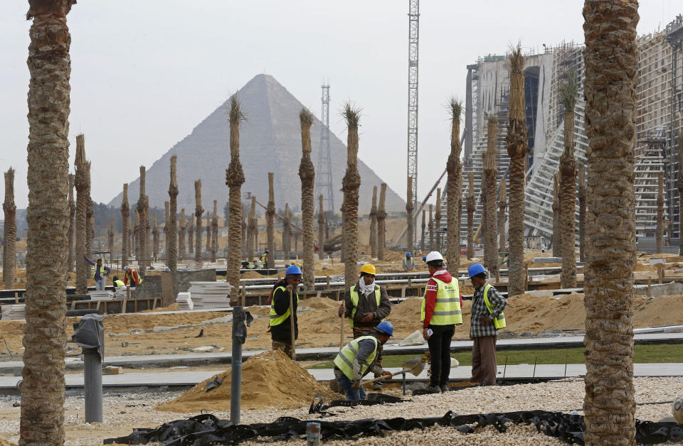 In this Sunday, Dec. 16, 2018 photo, workers landscape grounds at the Grand Egyptian Museum under construction in front of the Pyramids in Giza, Egypt. Thousands of Egyptians are laboring in the shadow of the pyramids to erect a monument worthy of the pharaohs. The Grand Egyptian Museum has been under construction for well over a decade and is intended to show off Egypt’s ancient treasures while attracting tourists to help fund its future development. (AP Photo/Amr Nabil)