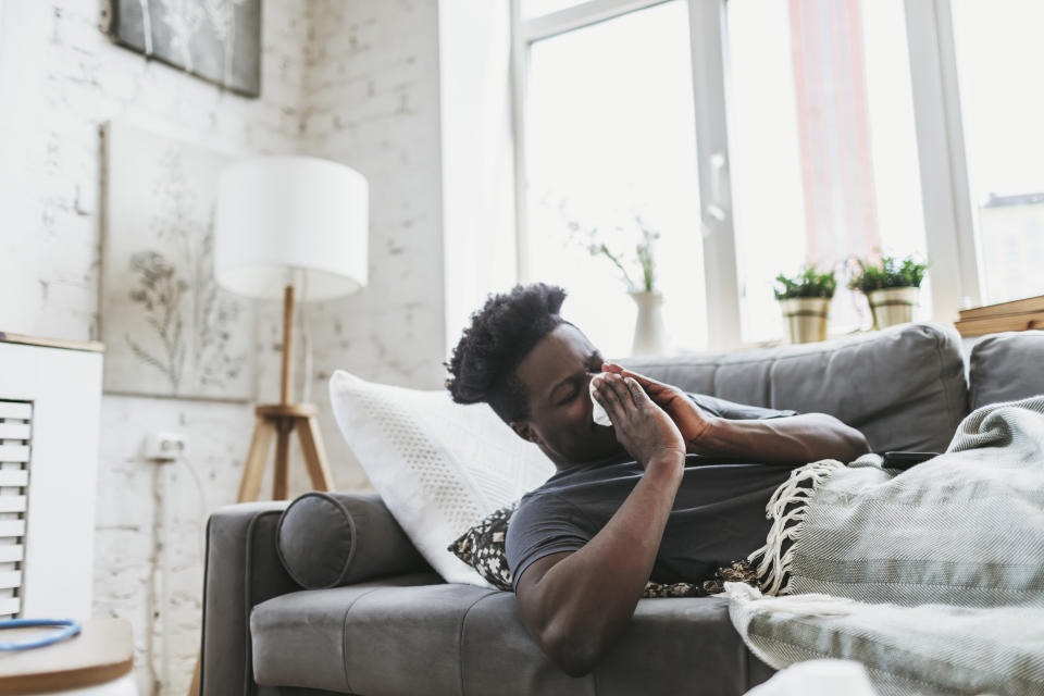 man at home on sofa with runny nose