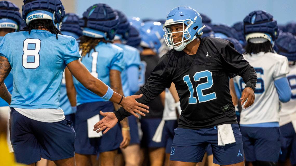 North Carolina graduate transfer quarterback Jacolby Criswell (12) greets receiver Kobe Paysour (8) during the Tar Heels’ first practice of the season on Monday, July 29, 2024 in Chapel Hill, N.C.