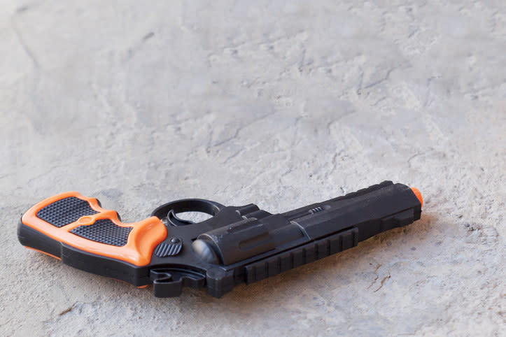 A toy gun laying on the floor.