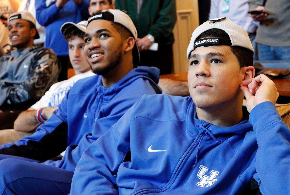 Karl-Anthony Towns, left, and Devin Booker along with other members of Kentucky's men's basketball team watch the NCAA college basketball tournament selection show at the home of head coach John Calipari in Lexington, Ky. March 15, 2015