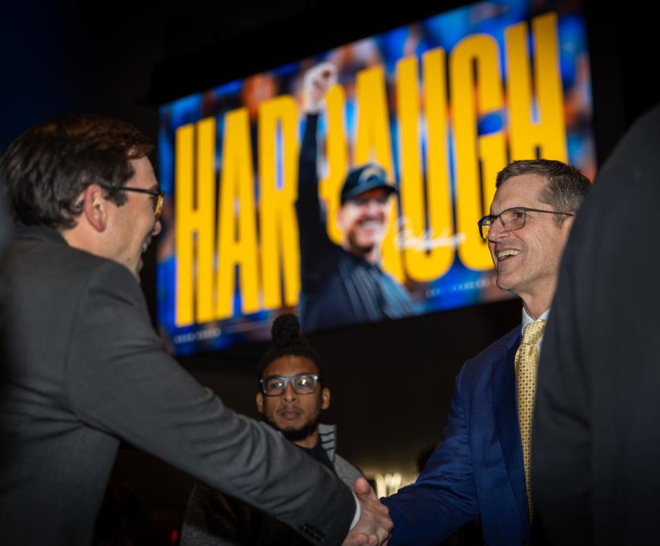 Chargers coach Jim Harbaugh greets people following his introductory news conference.