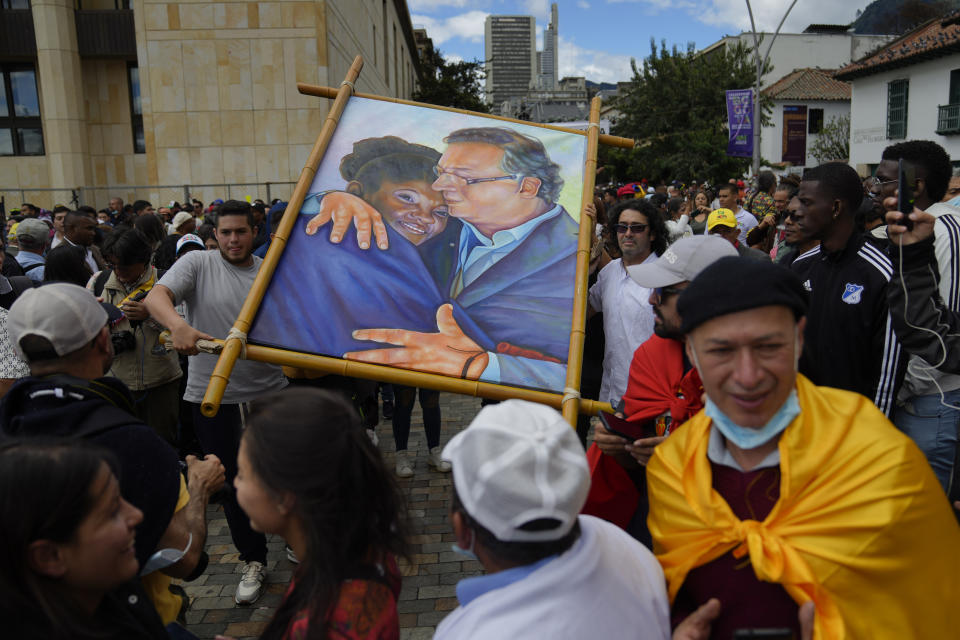 Supporters of new President Gustavo Petro display a painting of him with new Vice-President Francia Marquez as they wait for their swearing-in ceremony at the Bolivar square in Bogota, Colombia, Sunday, Aug. 7, 2022. (AP Photo/Ariana Cubillos)