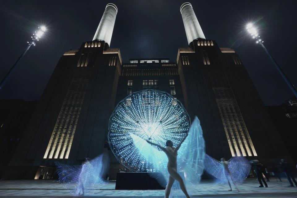 Performers dance in front of a light installation "Singularity" designed by artist Squidsoup, at the Battersea Power Station in London, Thursday, Jan. 25, 2024. The Light Festival involved seven light installations from British and international artists at Battersea Power Station, which illuminated the winter evenings between Jan. 25 and Feb, 25. (AP Photo/Kin Cheung)