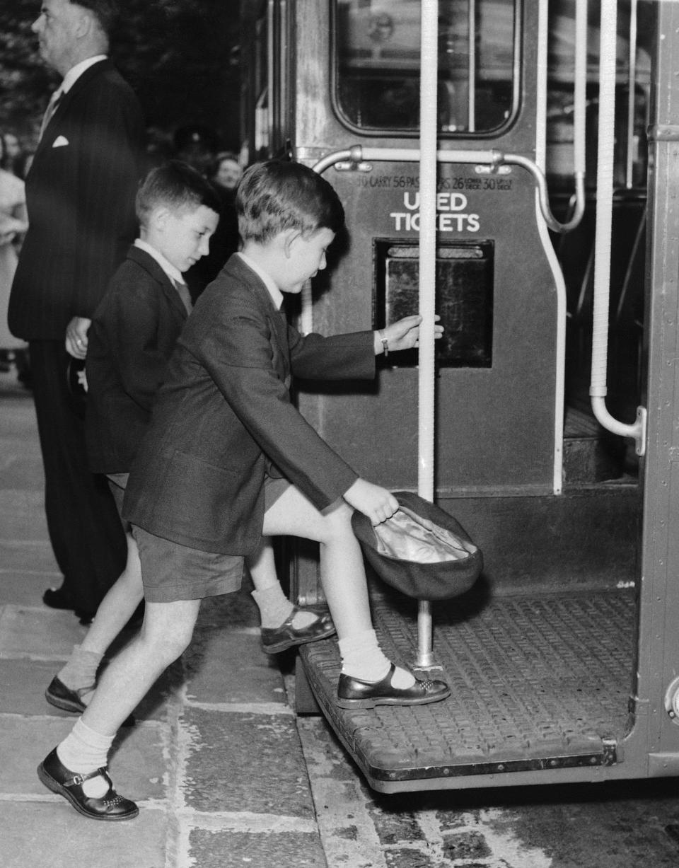 FILE - Britain's Prince Charles, foreground boards a London Transport hired bus with fellow pupils at Hill House school to attend the school's sports day, in London, July, 1957. King Charles III hasn’t even been crowned yet, but his name is already etched on the walls of Hill House School in London. A wooden slab just inside the front door records Nov. 7, 1956, as the day the future king enrolled at Hill House alongside other notable dates in the school’s 72-year history. (AP Photo, file)