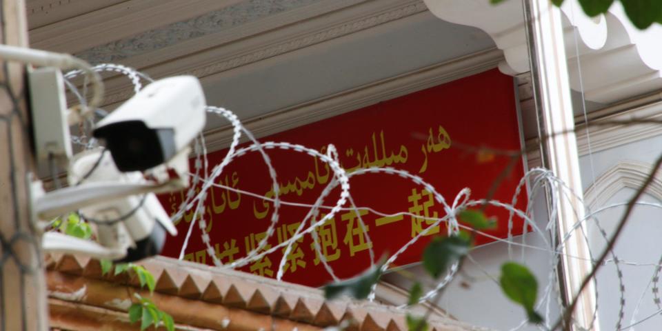 FILE PHOTO: A propaganda banner and a security camera are placed on the walls of a mosque in the Old City in Kashgar, Xinjiang Uighur Autonomous Region, China September 6, 2018. Picture taken September 6, 2018.  REUTERS/Thomas Peter