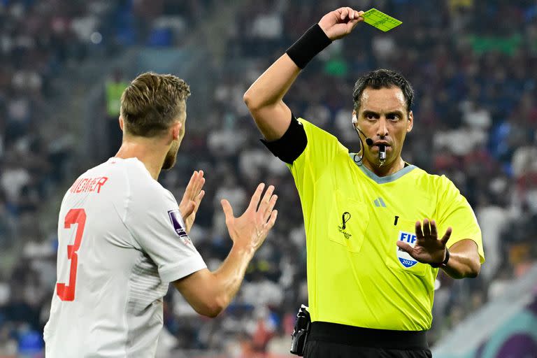 Fernando Rapallini le muestra una tarjeta amarilla a Silvan Widmer durante el partido que disputan Serbia y Suiza.